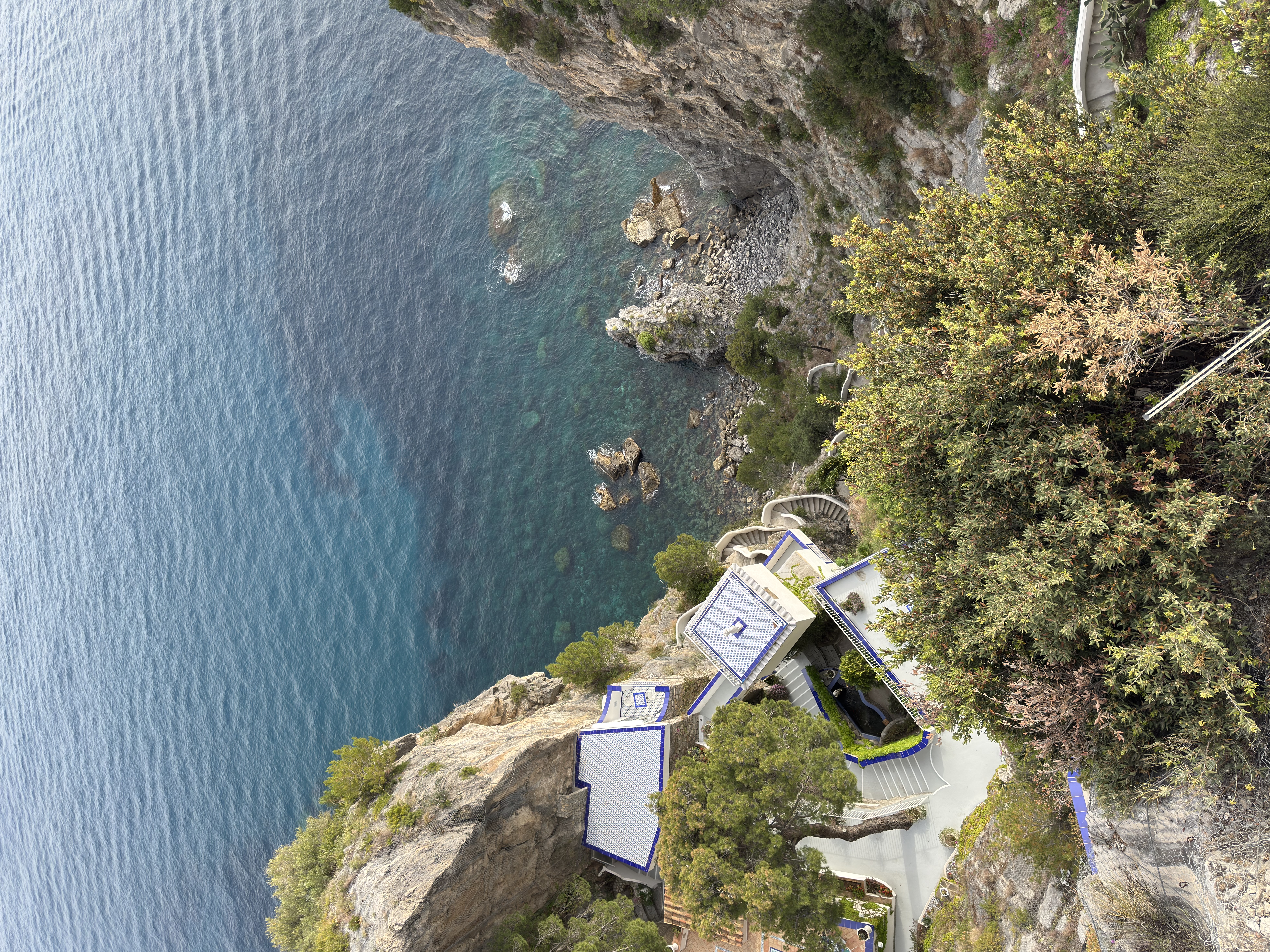 Aerial view of Grand Hotel Tritone beach and cliff from above, turquoise sea